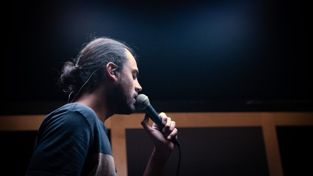 Instructor coaching a student on vocal projection in a rehearsal room
